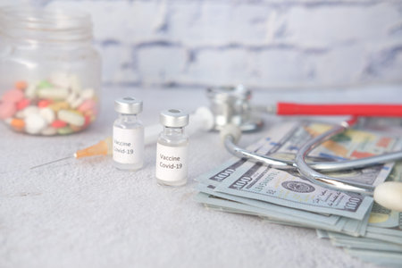 Healthcare cost concept with us dollar, vaccine and pillsの写真素材