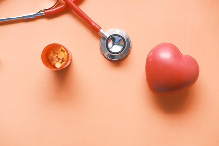heart shape symbol and stethoscope on orange backgroundの写真素材