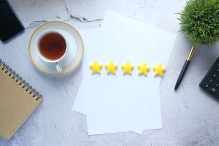 Customer review concept with Rating golden stars on tableの写真素材