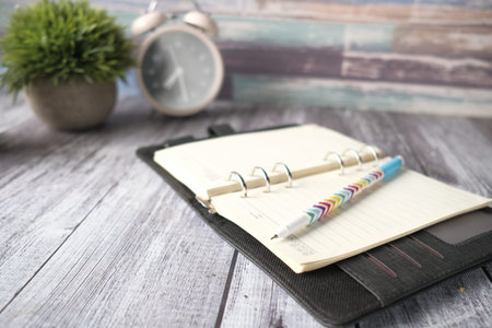 open notepad and pen on paper on wooden background