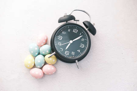 easter concept with egg and a clock on tableの写真素材