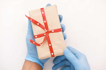 male hand in a blue medical glove gives a gift.の写真素材