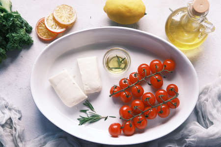 cherry tomato, cheese and olive oil on tableの写真素材