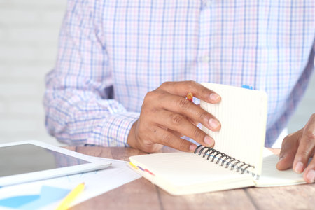 Close up of mans hand turning a pager of a diary