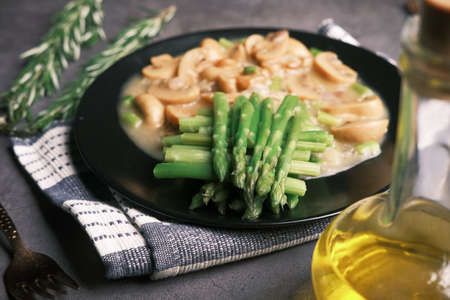 Asparagus green, olive oil and mushroom on plate black backgroundの写真素材