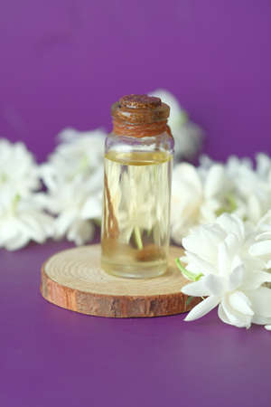 eucalyptus essential oils in a glass bottle and flower on purple backgroundの写真素材