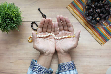 muslim man keep hand in praying gestures during ramadan, Close upの写真素材