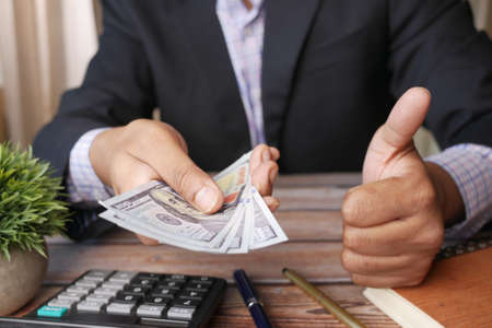 unrecognized businessman hand counting 100 us dollar cashの写真素材