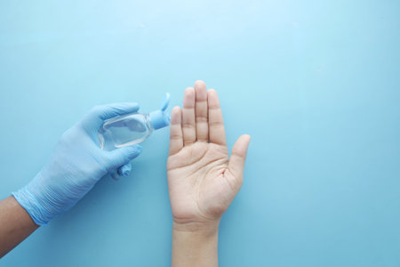 Using sanitizer liquid for preventing corona virus on blue background