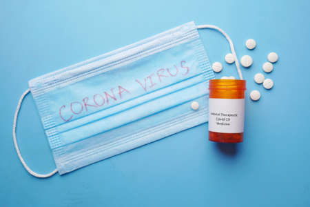 covid 19 medical pills and blue surgical masks on tableの写真素材