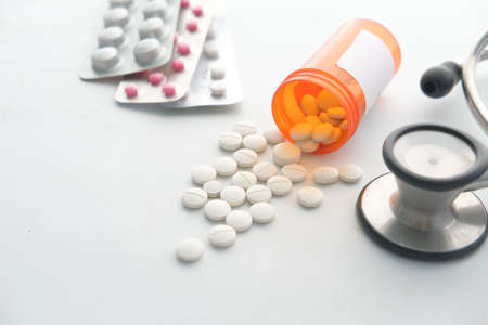 white color medical pills spilling on whiteの写真素材