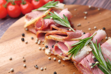 Raw fed bacon strips on chopping board .の写真素材