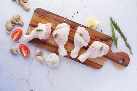 raw chicken drumstick on a chopping boardの写真素材