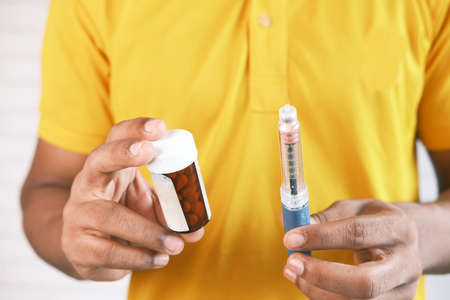 hand holding Insulin pens and pill containerの写真素材