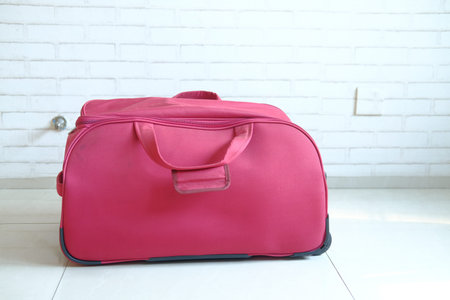 travel bag on floor against a wallの写真素材