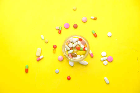 Close up of many colorful pills and capsules on yellowの写真素材