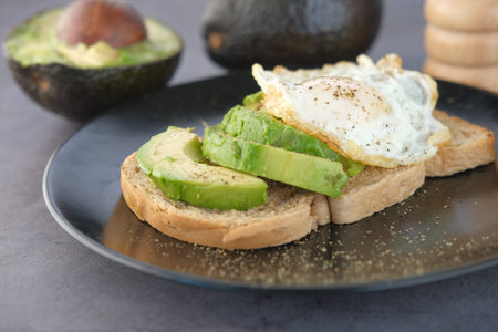 Avocado, brown bread, egg and rosemary on table