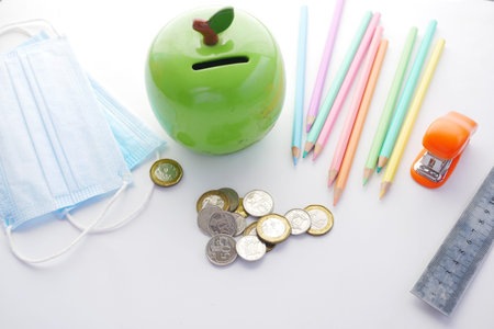 color pencils, face mask and coins on white backgroundの写真素材