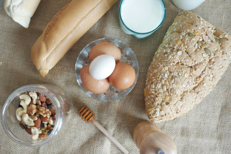 eggs in a bowl, whole meal bread and milk on table