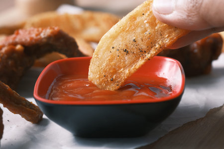 Tasty freshly made wage potato chips and sauce on table