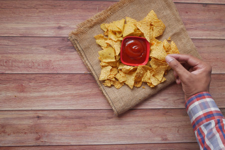 top view of man hand eating potato chips .の写真素材