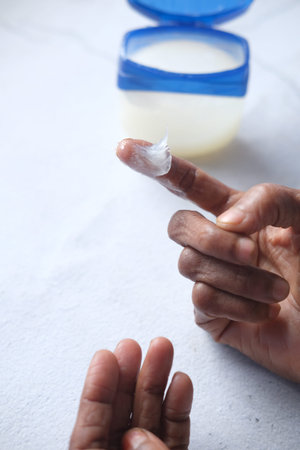 senior woman using petroleum jelly onto skin