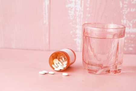 white color medical pills spilling on pinkの写真素材