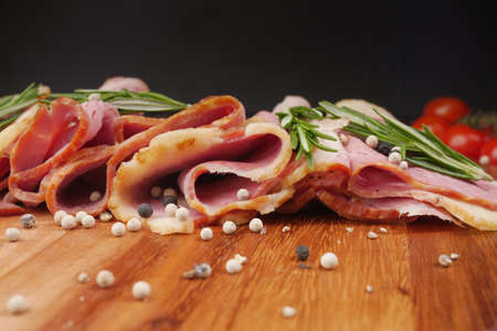Raw fed bacon strips on chopping board .の写真素材