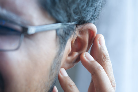 young man having ear pain touching his painful ear ,の写真素材