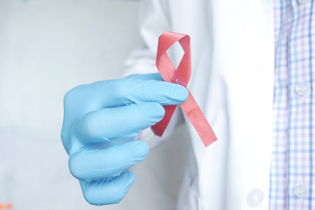 doctor hand holding pink color HIV ribbon close upの写真素材