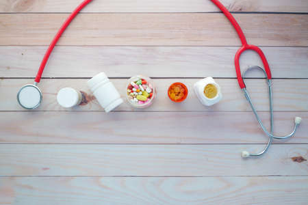 top view of medical pill containers and stethoscope on tableの写真素材