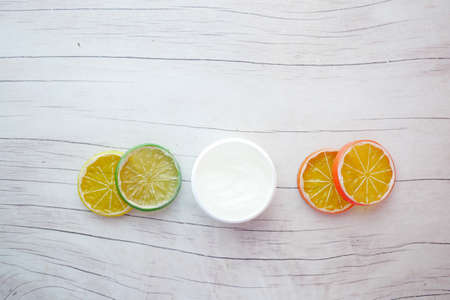 top view of petroleum jelly in a container and slice of lemon on tableの写真素材
