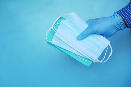 Medical glovers holding surgical face mask