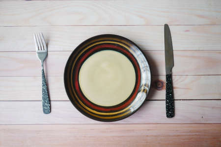 cutlery and empty plate on wooden background top downの写真素材