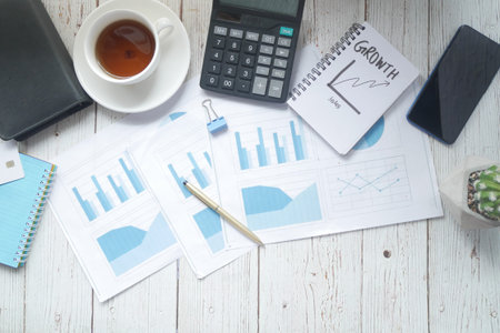 financial graph, calculator and notepad on table