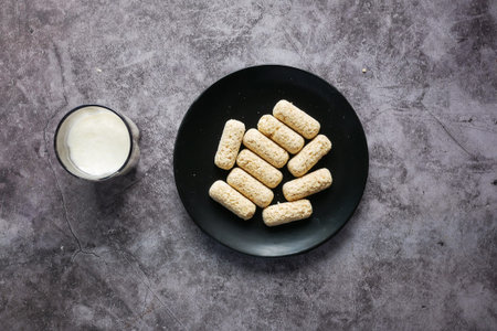 Tasty oats bars on a plate and glass of milk on table ,