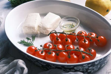 cherry tomato, cheese and olive oil on tableの写真素材