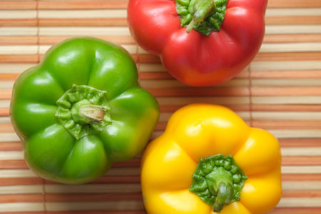 Yellow green and red capsicum on table, top view
