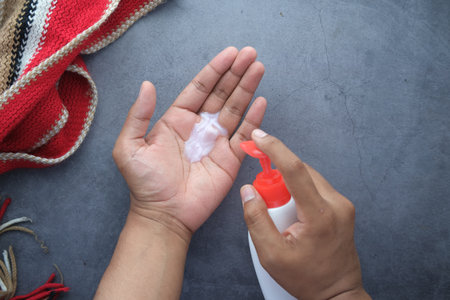 mans hand using liquid soap on black backgroundの写真素材