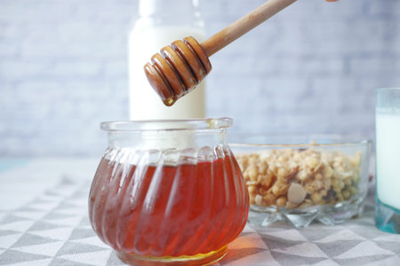 close up of fresh honey with spoon on table