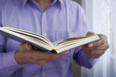 muslim man hand holding Holy book Quran with copy space