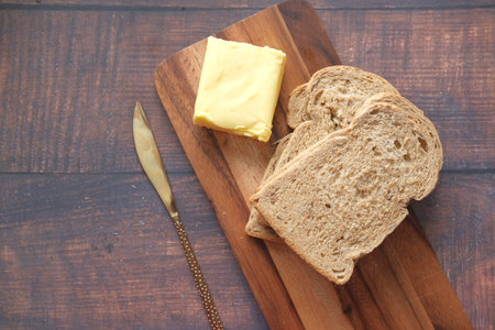slice of butter and whole meal bread on chopping board