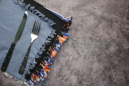 table napkin with knife and fork on table.
