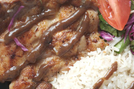 detail shot grill chicken , BBQ sauce, rice and salad on plate on tableの写真素材