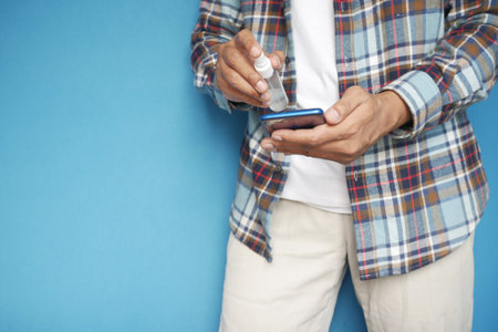 cleaning mobile phone display with sanitizer liquidの写真素材