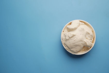 top view of milk cream in a container on blue background,の写真素材