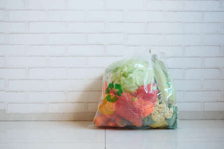 Recycled arrows sign on a shopping bag with vegetable on a floorの写真素材
