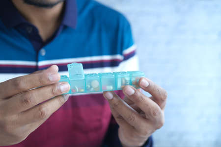 mans hands taking medicine from a pill boxの写真素材