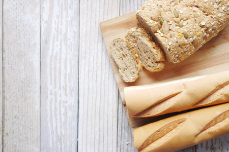 whole grain baked bread on chopping board on table