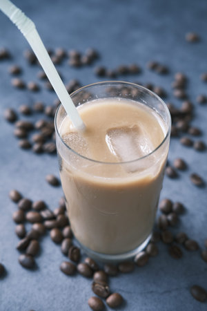 ice coffee in a tall glass on black background.